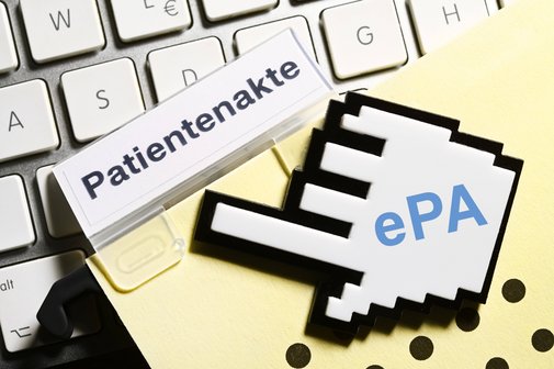 Symbolfoto elektronische Patientenakte ePA: Ein Computercursor zeigt auf eine gelbe Mappe mit der Aufschrift Patientenakte, die auf einer Computertastatur liegt.