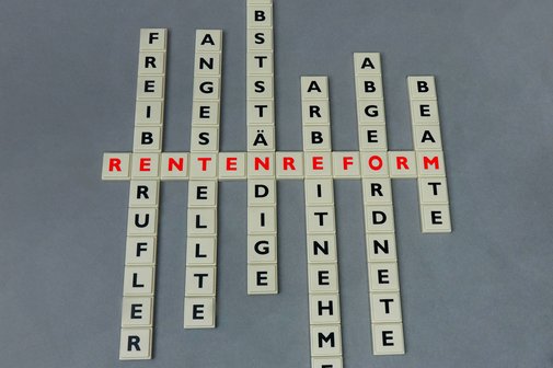 Quer liegende Scrabble-Buchstaben bilden das Wort Rentenreform, längst liegen mehrere andere Wörter wie Freiberufler, Beamte, Selbstständige, Angestellte, Arbeitnehmer