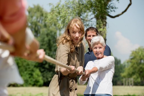&Auml;ltere Frau, j&uuml;ngere Fau und j&uuml;ngerer Mann ziehen an einem Tau.