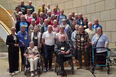 Die Reisegruppe hat sich auf der Treppe zum Plenarsaal im Landtag NRW zum Gruppenfoto aufgestellt.