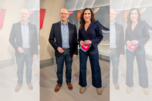 Ein Mann und eine Frau stehen nebeneinander in einem Fernsehstudio. Die Frau hat Moderationskarten in der Hand.