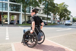 Frau im Rollstuhl am Straßenrand