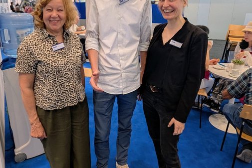 Gruppenfoto: die Servicekräfte Silvia und Niklas gemeinsam mit VdK-Veranstaltungsmanagerin Liza Franke am VdK-Stand.