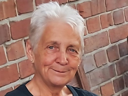 Portrait einer Frau mit kurzen, wei&szlig;en Haaren.