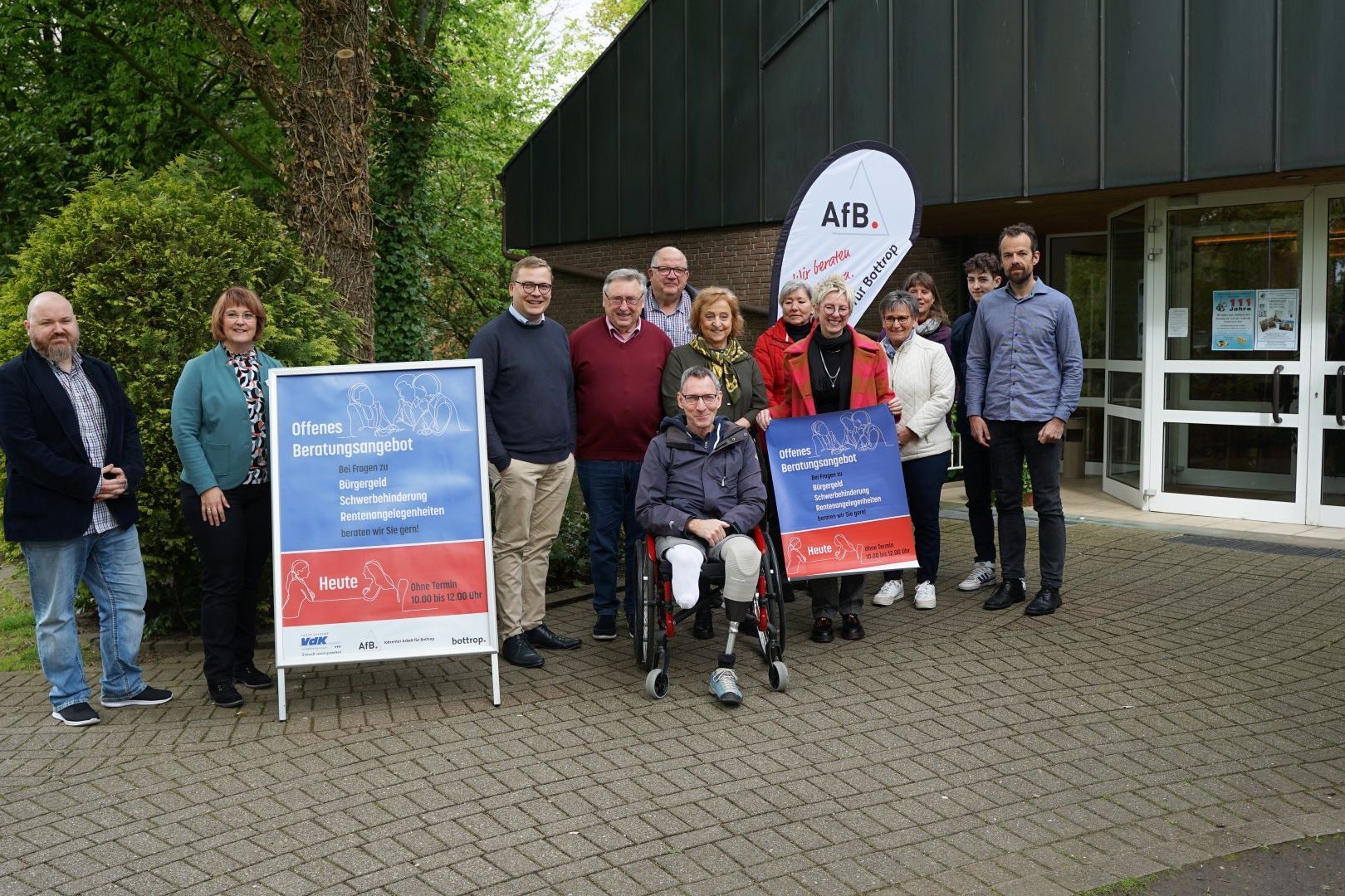 Sozialberatung Vertreter des VdK Bottrop, VdK Kirchhellen sowie des Sozialamts und Jobcenters stehen bei der offiziellen Vorstellung ihres gemeinsamen Projekts als Gruppe neben Aufstellern und einer Beachflag..