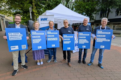 1 Frau und 5 Männer halten mit beiden Händen blaue Plakate in die Kamera. Auf den Plakaten stehen verschiedene sozialpolitische Forderungen des VdK drauf.