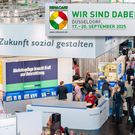 Foto der Messehalle mit VdK-Stand und auf einem Banner die Info: Wir sind dabei Halle 6 Stand C16