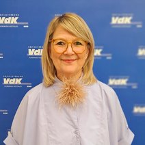 Porträt von Vera Hoffmann vor einem Roll-up mit dem Logo des VdK NRW