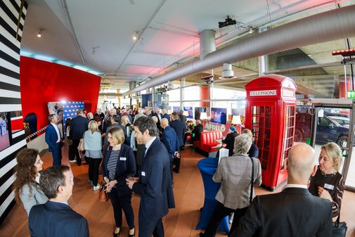Gesamtblick ins Foyer des Apollo-Theaters. Rund 30 Menschen unterhalten sich, in der Mitte steht eine alte, rote Telefonzelle.