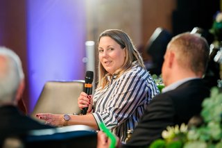 Frau Schmitz-Kießler spricht während der Podiumsdiskussion in ihr Mikrofon.