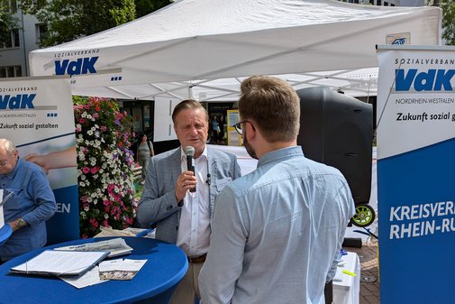 FDP-Kandidat Heiko Müller im Gespräch mit Benedikt Lechtenberg vom VdK-Landesverband vor dem VdK-Zelt