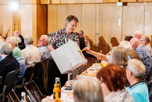 eine Frau hält eine Wahlbox