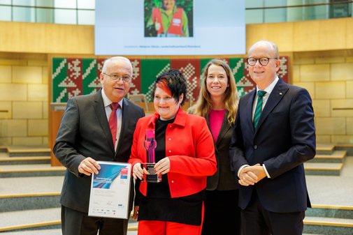 Gruppenfoto der Preistr&auml;gerin gemeinsam mit Jury, Schirmherr und Laudatorin im Plenarsaal des Landtags. 