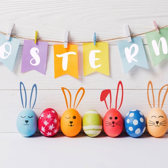an einer Kordel h&auml;ngen in bunt die Buchstaben O S T E R N. Darunter liegen sieben bunte Eier als H&auml;schen gebastelt.