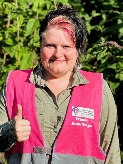 Portrait von Susanne Höch in pinker Warnweste mit Logo: Frauenbeauftragte.
