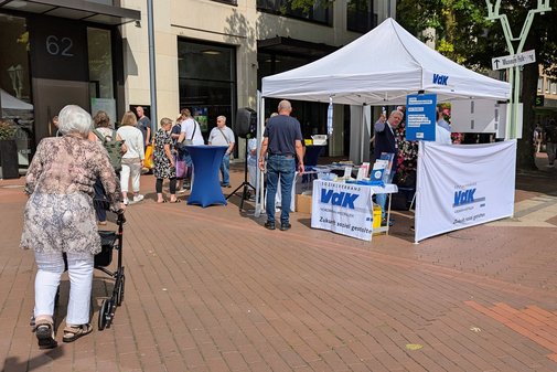 eine ältere Frau am Rollator steuert auf den VdK-Stand zu