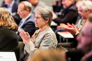 Frau Siedentop sitzt im Publikum und applaudiert gemeinsam mit weiteren Gästen