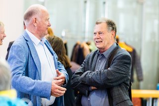 Zwei Männer stehen im Foyer der Stadthalle und unterhalten sich.