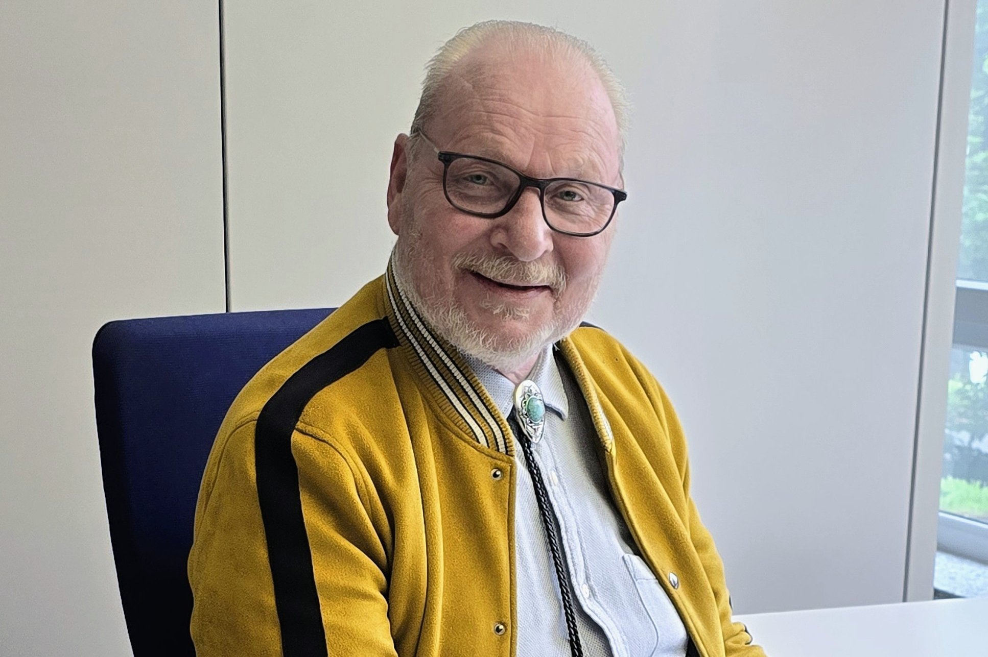 Peter Ries sitzt im Büro am Schreibtisch