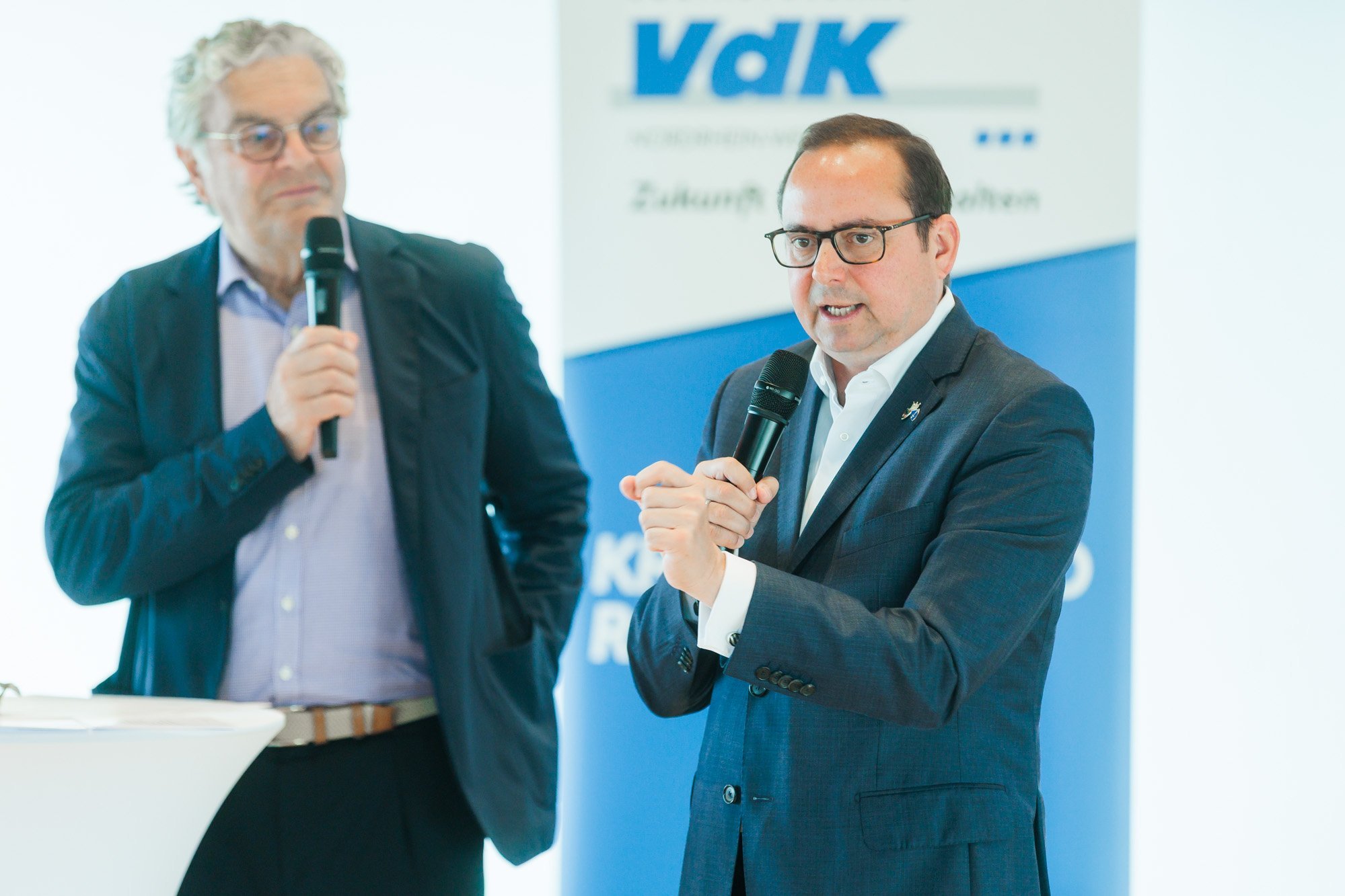 Oberbürgermeister Thomas Kufen spricht ins Mikrofon. Links im Hintergrund steht Moderator Jürgen Zurheide, ebenfalls mit Mikrofon in der Hand.