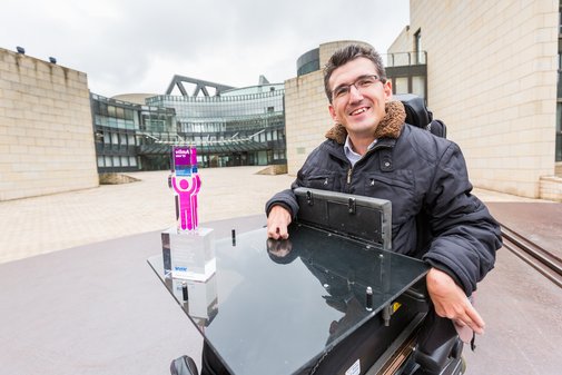 vilmA-Preisträger mit Pokal im Rollstuhl vor dem Veranstaltungsgebäude.