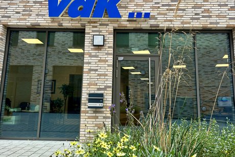 Die Geschäftsstelle des Kreisverbands Steinfurt, Ziegelwand mit großen Glasfenstern und blauem VdK-Logo obendrüber.