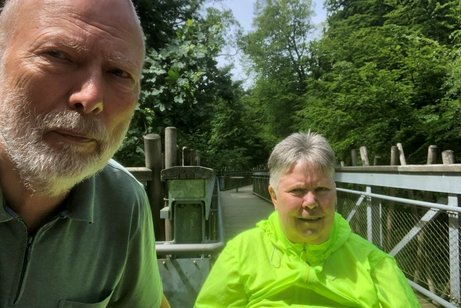 Manfred und Lydia Zehe auf einem Holzstieg des Baumwipfelpfades, im Hintergrund Wald und Bäume.