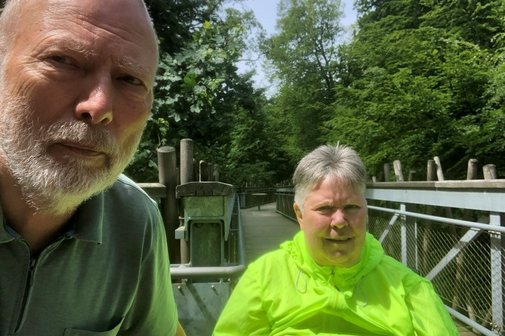 Manfred und Lydia Zehe auf einem Holzstieg des Baumwipfelpfades, im Hintergrund Wald und Bäume.