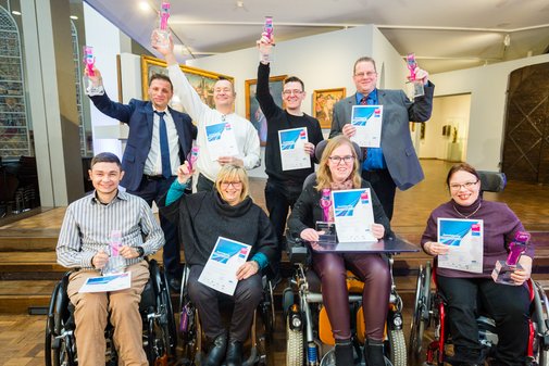 Gruppenfoto fröhlicher vilmA-Gewinnerinnen, stehend und im Rollstuhl sitzend. 