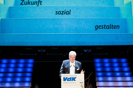 VdK-Vizepräsident Peter Jeromin steht am VdK-Rednerpult. Im Hintergrund leuchtet eine Leinwand mit dem VdK-Schriftzug Zukunft sozial gestalten
