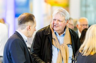 Zwei Männer unterhalten sich im Foyer der Stadthalle Neuss.