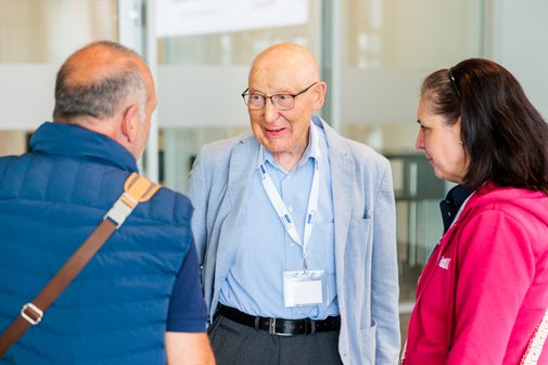 ein Mann unterhält sich mit einem anderen Mann und einer Frau