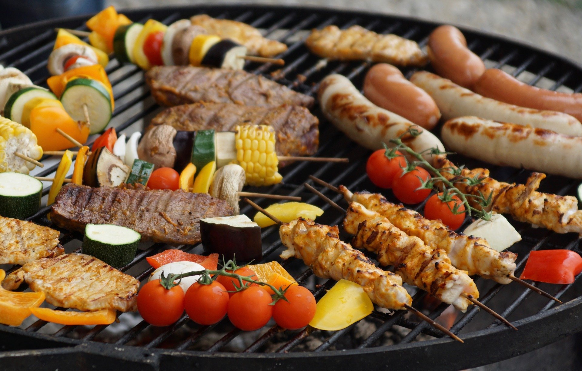 Fleisch, W&uuml;rstchen und Gem&uuml;se auf einem Grill