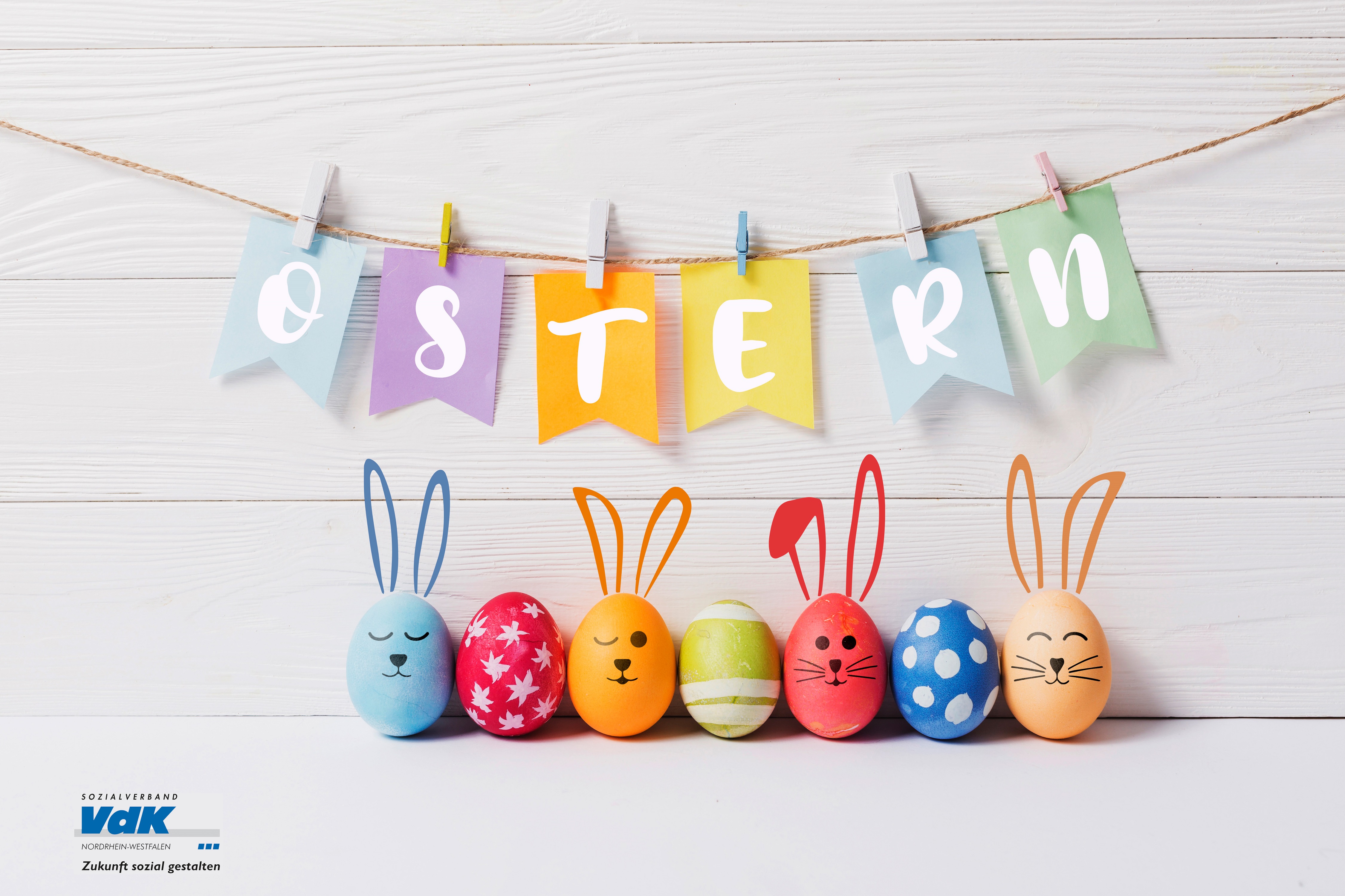 Bunte Hasen aus Ostereiern stehen nebeneinander unter einer bunten Buchstaben-Girlande mit dem Wort "Ostern". Unten links im Bild das VdK-NRW-Logo.