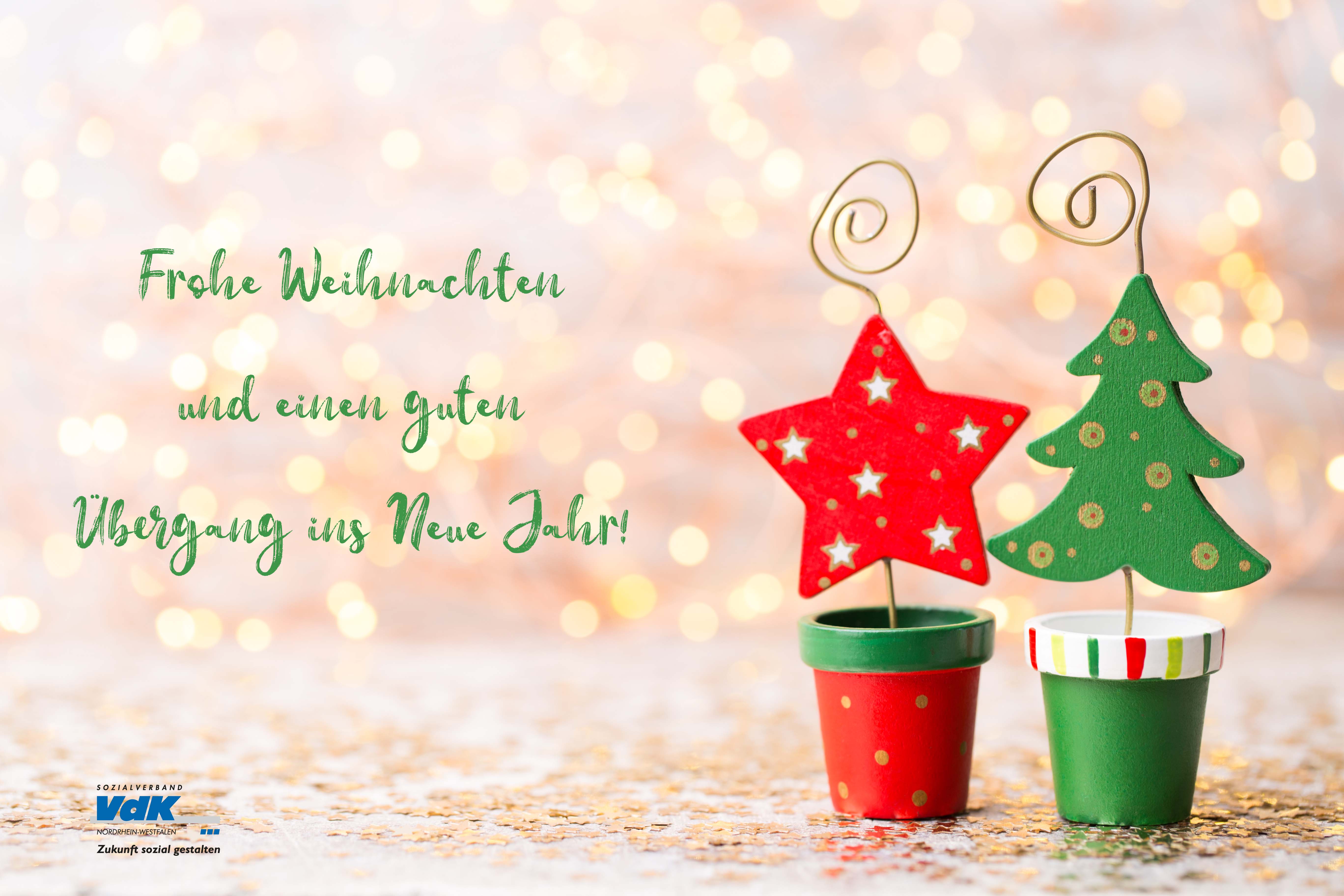 Weihnachtsmotiv: Tanne und Stern aus Holz in kleinen Tontöpfchen. Daneben in grüner Schrift: Frohe Weihnachten und einen guten Übergang und das VdK-NRW-Logo.