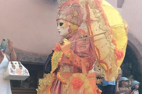 Prächtige venezianische Karnevalsköstüme vor historischer Kulisse in Riquewihr.