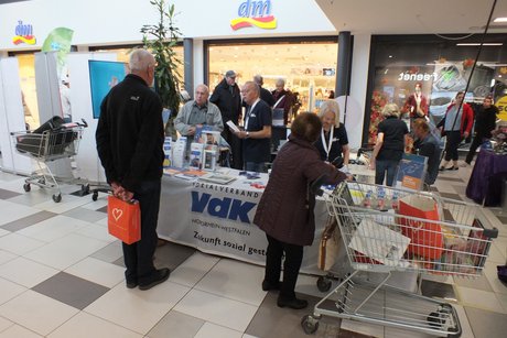 Mehrere Personen stehen an einem Info-Tisch.