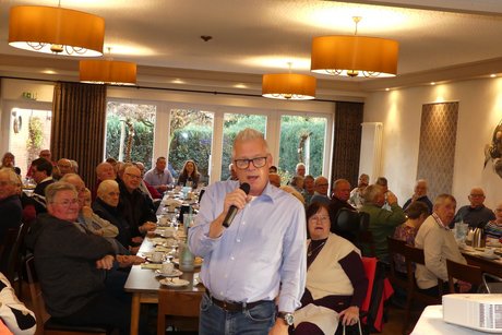 Vortrag des Kriminalhauptkommissar Christoph Wegener zum Thema Trickbetrug etc. Im Vordergrund der Kriminalhauptkommissar Christoph Wegener mit Mikrofon, im Hintergrund viele Personen an Tischen