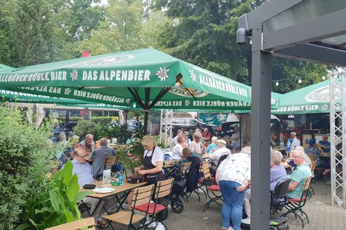 Gäste sitzen im Biergarten.