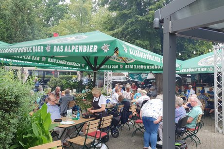 G&auml;ste sitzen im Biergarten.