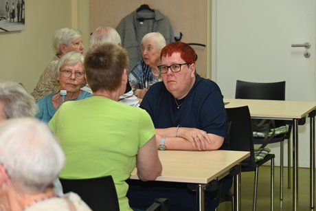 Menschen sitzen am Tisch bei einer Unterhaltung