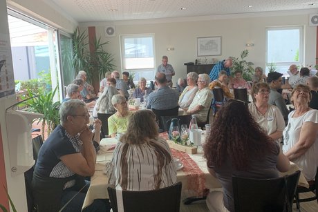 Mitglieder sitzen an den Tischen im Saal