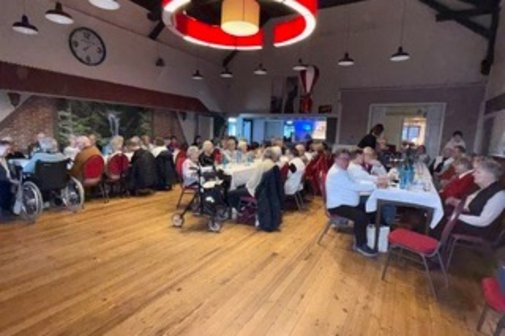 Mitglieder sitzen in gem&uuml;tlicher Atmosph&auml;re an Tischen.