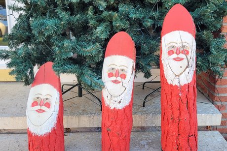 Weihnachten 3 selbstgebastelte Nikoläuse stehen nebeneinander dahinter eine Tanne.