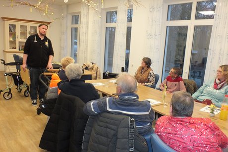 Ein Mann steht vor einer Gruppe und h&auml;lt einen Vortrag.