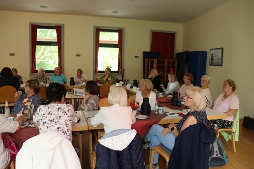 Vertreterinnen der Frauen sitzen an Tischen zusammen.