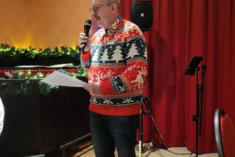 Arno Wachtel begr&uuml;&szlig;t die Mitglieder in einem sch&ouml;nen roten Weihnachtspullover