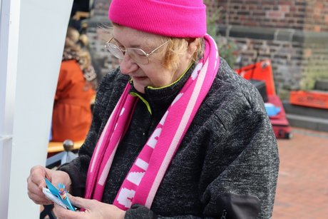 Eine Frau mit pinkfarbener M&uuml;tze und Schal.