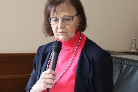Eine Frau lie&szlig;t etwas von einem Zettel ab.