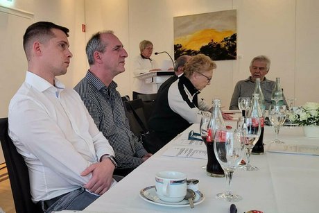 Foto der Vorstandsmitglieder gemeinsam an einem Tisch.